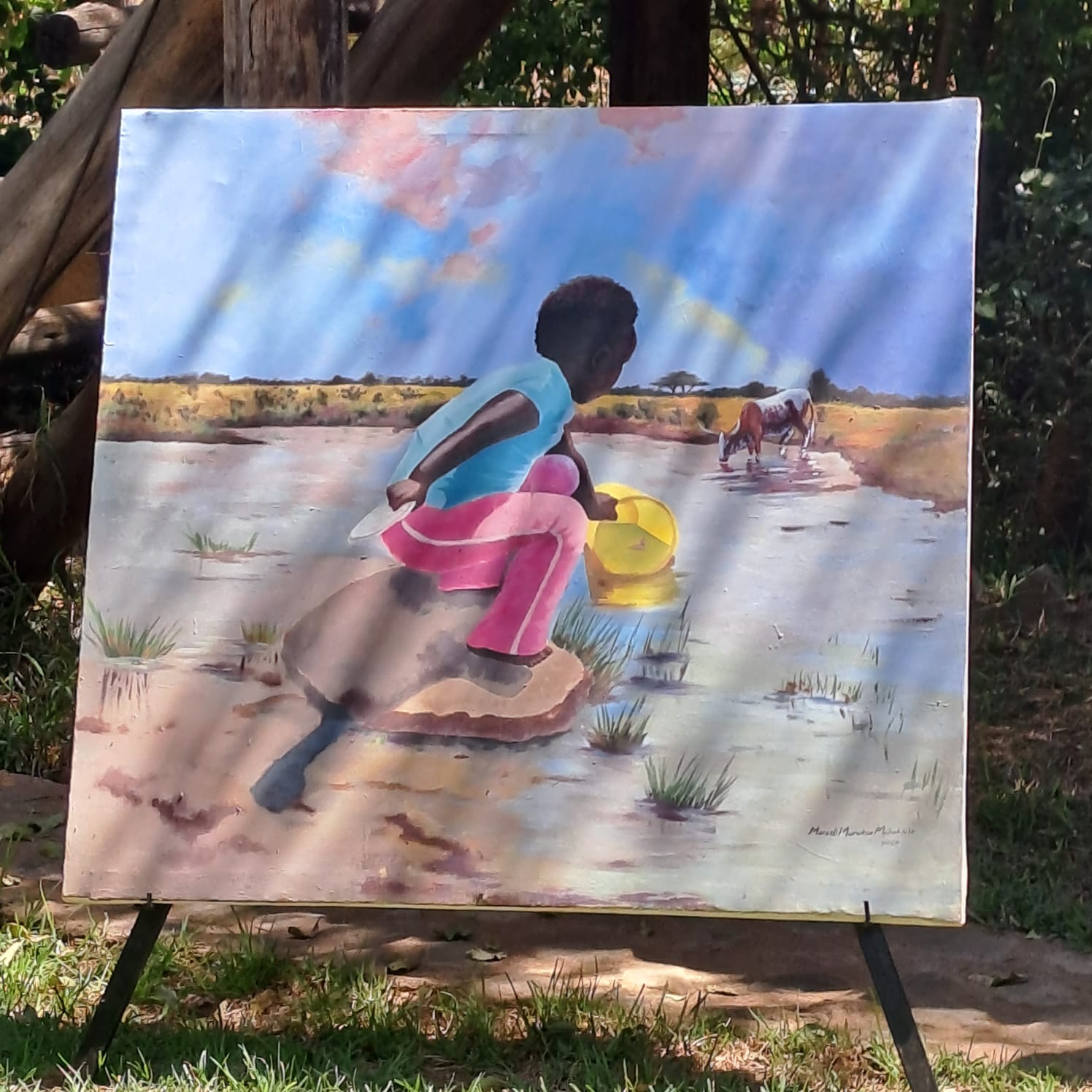 Little girl fetching water from a stream